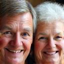 Margaret, an elderly woman, with her adult son, both smiling warmly.
